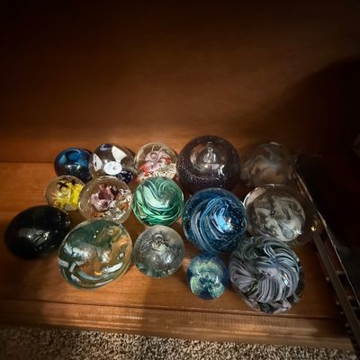Sale Photo Thumbnail #40: Collection of assorted art glass paperweights displaying various colors, swirls, and controlled bubble designs.