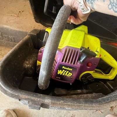 Sale Photo Thumbnail #72: Poulan Wild Thing model 2375 gas chainsaw in bright green and purple housing, resting inside its black hard plastic carrying case.
