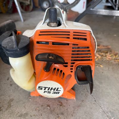 Sale Photo Thumbnail #69: Stihl FS 38 gas-powered string trimmer motor housing, showing typical wear from outdoor use.