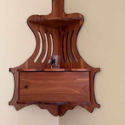 Sale Photo Thumbnail #44: Vintage handcrafted cedar corner wall shelf featuring cut-out side slats, an upper tier, and a drop-down lower cabinet compartment.