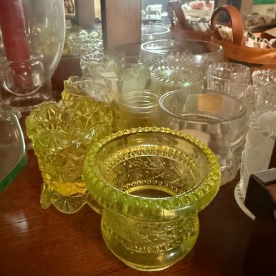 Sale Photo Thumbnail #95: Collection of vintage glass candle holders, featuring pressed yellow Vaseline glass and clear patterned glass pieces.