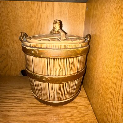 Sale Photo Thumbnail #25: Vintage McCoy ceramic cookie jar designed to resemble a faux-wood barrel with a lid and handle, featuring a light brown glaze with darker accents.