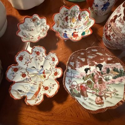 Sale Photo Thumbnail #88: Collection of vintage Japanese Kutani ceramic dishes and bowls featuring hand-painted geisha figures, landscapes, and scalloped edges.