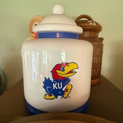 Sale Photo Thumbnail #5: Vintage Kansas Jayhawks ceramic cookie jar with lid, featuring the classic KU mascot graphic.