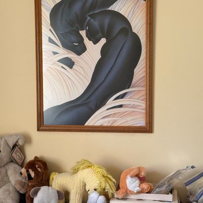 Sale Photo Thumbnail #129: Framed 1980s Art Deco style black panther print in a wooden frame, hanging above a shelf with plush toys and hardcover books.