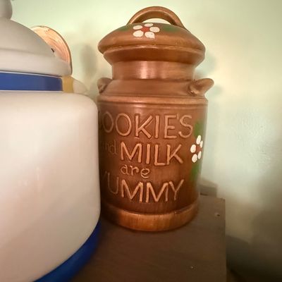 Sale Photo Thumbnail #4: Vintage ceramic milk can cookie jar featuring embossed lettering 'COOKIES and MILK are YUMMY' and hand-painted floral accents, circa 1970s.