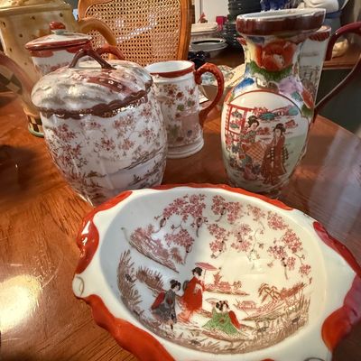 Sale Photo Thumbnail #87: Collection of vintage Japanese Kutani porcelain pieces, including a ruffled bowl, pitcher, and covered jar decorated with geisha figures and cherry blossoms.