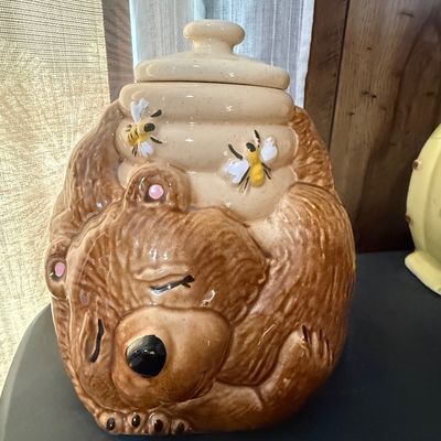 Sale Photo Thumbnail #30: Vintage ceramic sleeping bear cookie jar featuring a beehive lid with bumblebee accents.