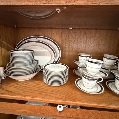 Vintage fine china dinnerware set featuring floral trim with dark blue bands, including teacups, saucers, plates, bowls, platters, and...