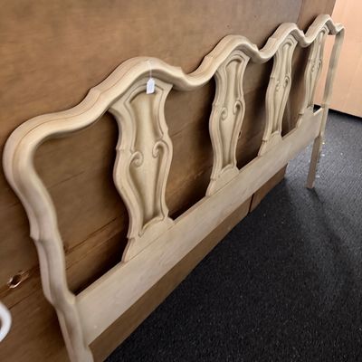 French Provincial style carved wooden headboard with a cream painted finish and serpentine crest line.
