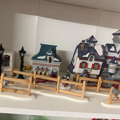 Collection of Christmas village illuminated ceramic buildings and accessories, including a post office, barber shop, street lamps, and...
