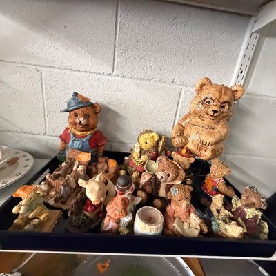 Collection of resin bear figurines arranged on a black plastic tray, featuring various dressed character designs and small decorative...
