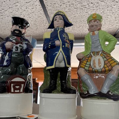 Set of three vintage ceramic figural liquor decanters depicting a pirate, a naval officer, and a Scotsman in a kilt.