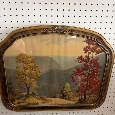 Framed vintage landscape print depicting a mountain scene with autumn trees, set in an ornate arched antique-style gold frame.