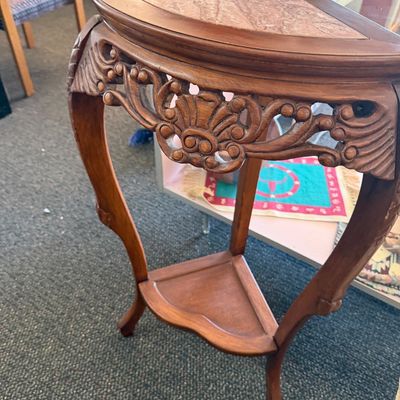 Vintage carved wood corner table featuring an inlaid pink marble top, ornate shell motif apron, and a lower display shelf.