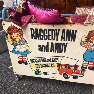 Vintage Raggedy Ann and Andy Toy Moving Co. rolling toy chest featuring colorful printed character graphics and original caster wheels,...