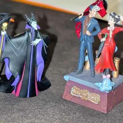 Sale Photo Thumbnail #53: Pair of Disney collectible figurines featuring Maleficent with her raven staff and a Mary Poppins 'Step in Time' chimney sweep scene.