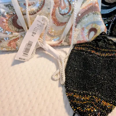 Sale Photo Thumbnail #85: Selection of beaded evening purses, including an ivory clutch with swirling pastel sequin detail and original tags attached, alongside a vintage black beaded pouch.
