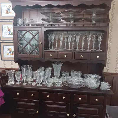 Sale Photo Thumbnail #21: Traditional dark wood hutch filled with an extensive collection of Waterford Crystal cut glass and crystal, including stemware, cake stands, bowls, and vases.