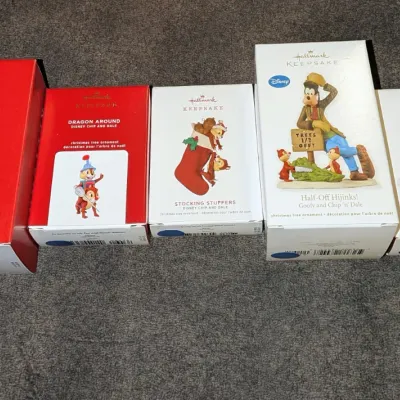 Sale Photo Thumbnail #39: Collection of five boxed Hallmark Keepsake Disney Christmas tree ornaments, featuring characters like Chip 'n' Dale, Goofy, and Mickey Mouse.