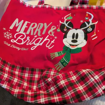 Sale Photo Thumbnail #83: Red canvas Walt Disney World holiday tote bag featuring embroidered Mickey Mouse with antlers and 'Merry & Bright' lettering, trimmed with red plaid fabric.