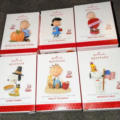 Sale Photo Thumbnail #63: Collection of six Hallmark Keepsake Peanuts-themed Christmas tree ornaments in original boxes, including designs for Thanksgiving, Halloween, Valentine's Day, and patriotism.