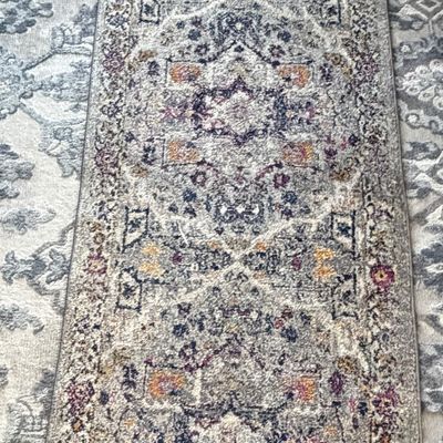 Traditional Persian-style runner rug with an intricate distressed pattern in shades of blue, cream, and muted yellow.