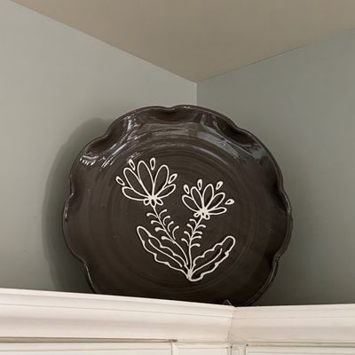 Handcrafted ceramic platter with scalloped rim and white sgraffito-style floral 