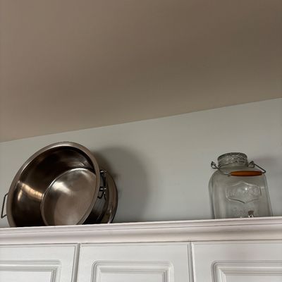 Large stainless steel stockpot and a clear glass drink dispenser with a wooden handle
