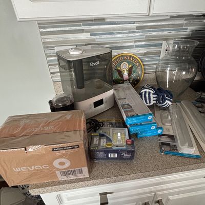 Assortment of household items on a kitchen counter, including a Levoit humidifier