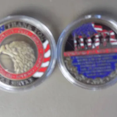 Pair of patriotic military veteran appreciation challenge coins housed in clear protective plastic cases.