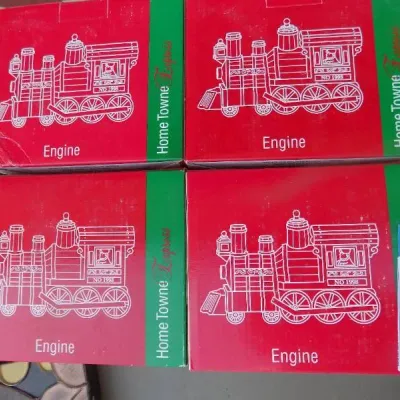 Set of four Home Towne Express 1998 train engine collectible building boxes, new in original red packaging.