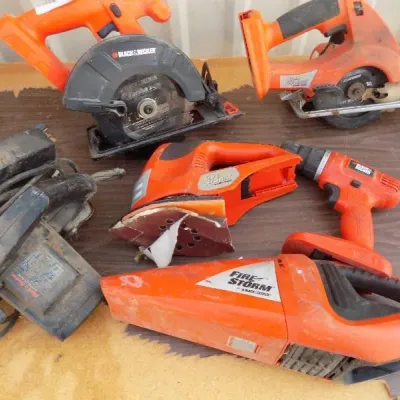 Assortment of pre-owned Black & Decker power tools, including cordless circular saws, a drill, a detail sander, a handheld vacuum,...