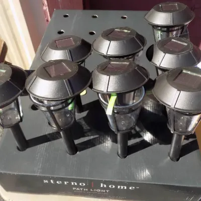 Set of eight Sterno Home solar outdoor path lights arranged in their original display box.
