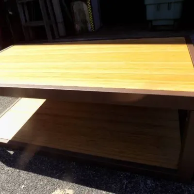 Modern industrial-style coffee table featuring a dark brown metal frame with light wood planked top and lower shelf.