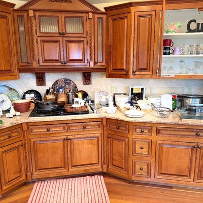 Kitchen counter filled with small appliances and dishware, including a Cuisinart food processor, Keurig coffee maker, slow cooker, and...