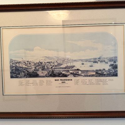 Framed vintage print depicting a historical panoramic view of San Francisco in 1849, presented with double matting in a dark wood frame.