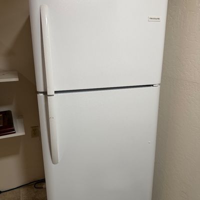 White Frigidaire top-freezer refrigerator, appearing clean and in good working condition.