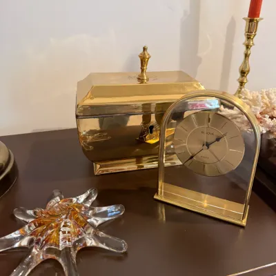 Sale Photo Thumbnail #17: Bulova brass and glass arched desk clock displayed alongside a polished brass lidded box and a starburst glass dish.