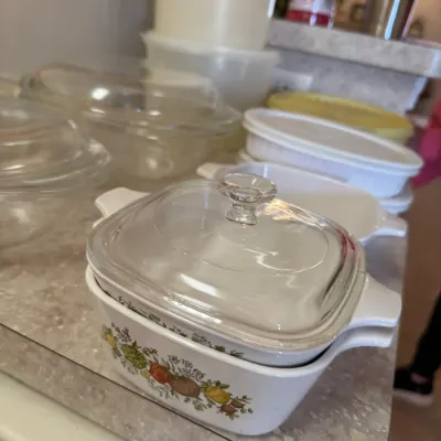 Sale Photo Thumbnail #72: Vintage Corning Ware Spice O' Life pattern square casserole dish with glass lid, displayed among other glassware and plastic containers.