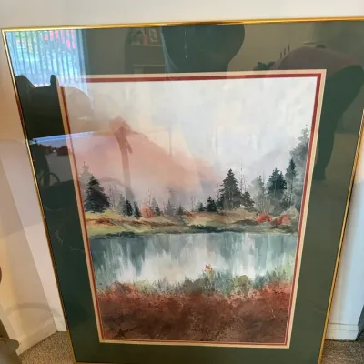 Sale Photo Thumbnail #37: Framed watercolor print depicting a serene forest lake landscape, presented in a thin brass metal frame with green and red double matting.