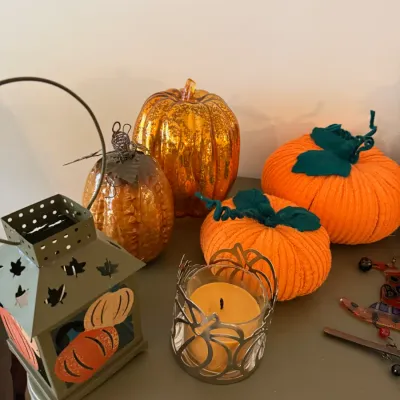 Sale Photo Thumbnail #34: Collection of autumn and Halloween decorations, including metallic mercury glass pumpkins, knit fabric pumpkins, a small candle holder, and a metal lantern.