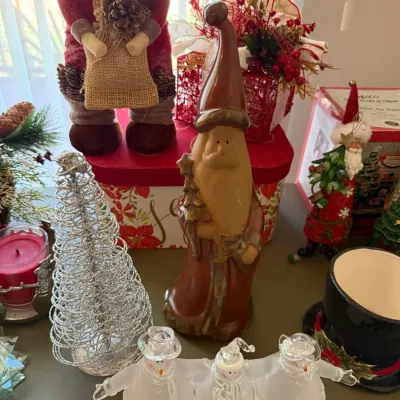 Sale Photo Thumbnail #27: Collection of Christmas decorations, including a tall clay Santa figurine, a trio of frosted glass snowmen, a silver wire tree, and fabric Santa figures.