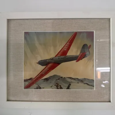 Framed vintage-style aviation print featuring a red and grey Soviet Tupolev ANT-25 airplane in flight over snowy mountains, set in a...