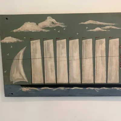 Folk art nautical painting on a wood panel featuring a multi-masted sailboat with an American flag.