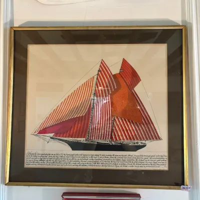 Framed nautical art print depicting the yacht Mohawk with red-and-white striped sails, paired with a decorative red and white half-hull...