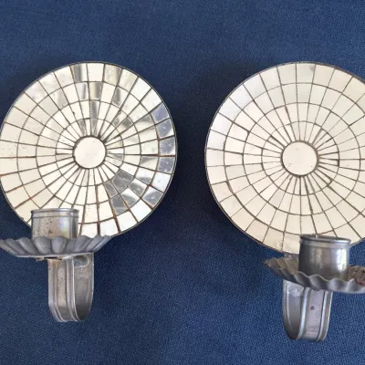 Pair of vintage tin and mirrored glass mosaic wall sconce candle holders, featuring round reflectors with radial tile patterns.
