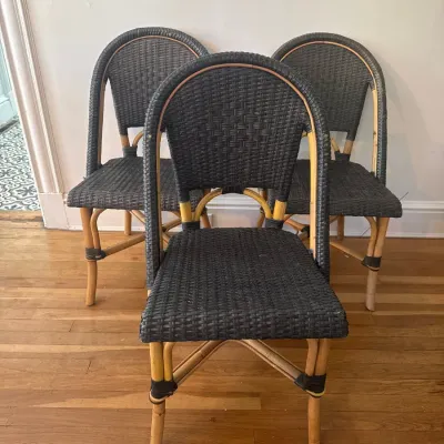 Set of three French bistro style chairs featuring natural rattan frames with dark woven synthetic wicker seats and backs.