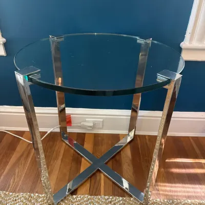Contemporary round glass-top side table featuring polished chrome geometric legs and an X-base frame.