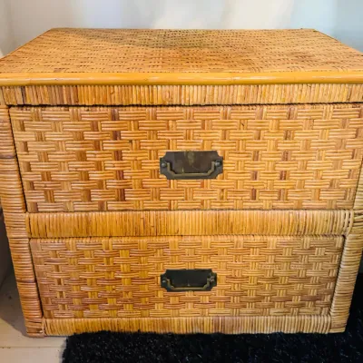 Vintage woven rattan nightstand featuring two drawers with brass campaign-style hardware.